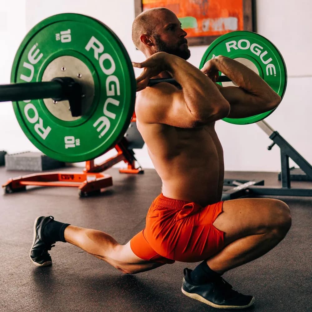 Athlete in a barbell front-rack lunge during a hard leg session